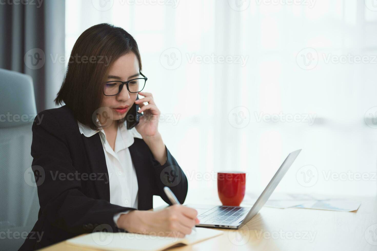 Freelance business woman calling on mobile smartphone while working with laptop, businesswoman mobile phone to calling with customers or shopping online. Smart phone conversation conferrence. photo