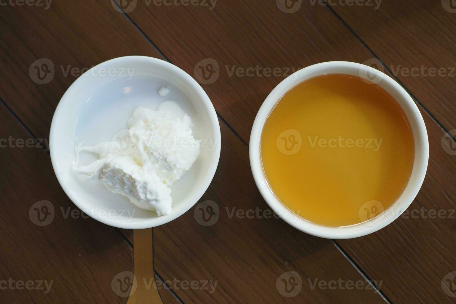 butter cream and honey in a bowl on table . photo