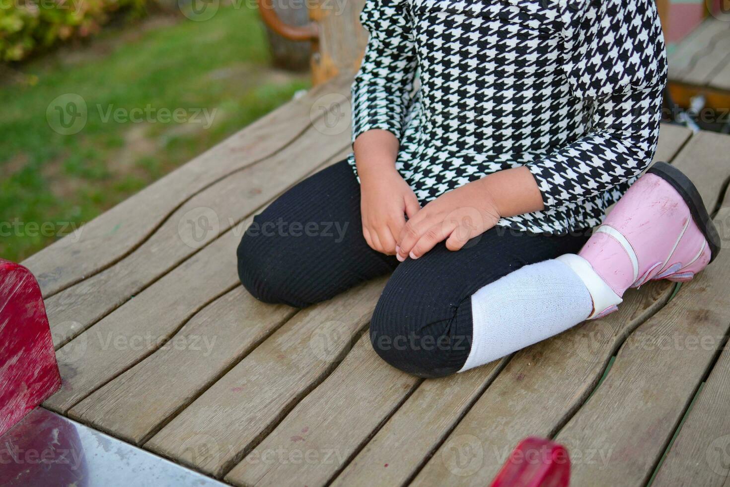 child sitting W posture on the floor . photo