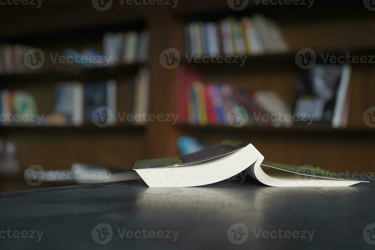 open book and a pencil on wooden table photo