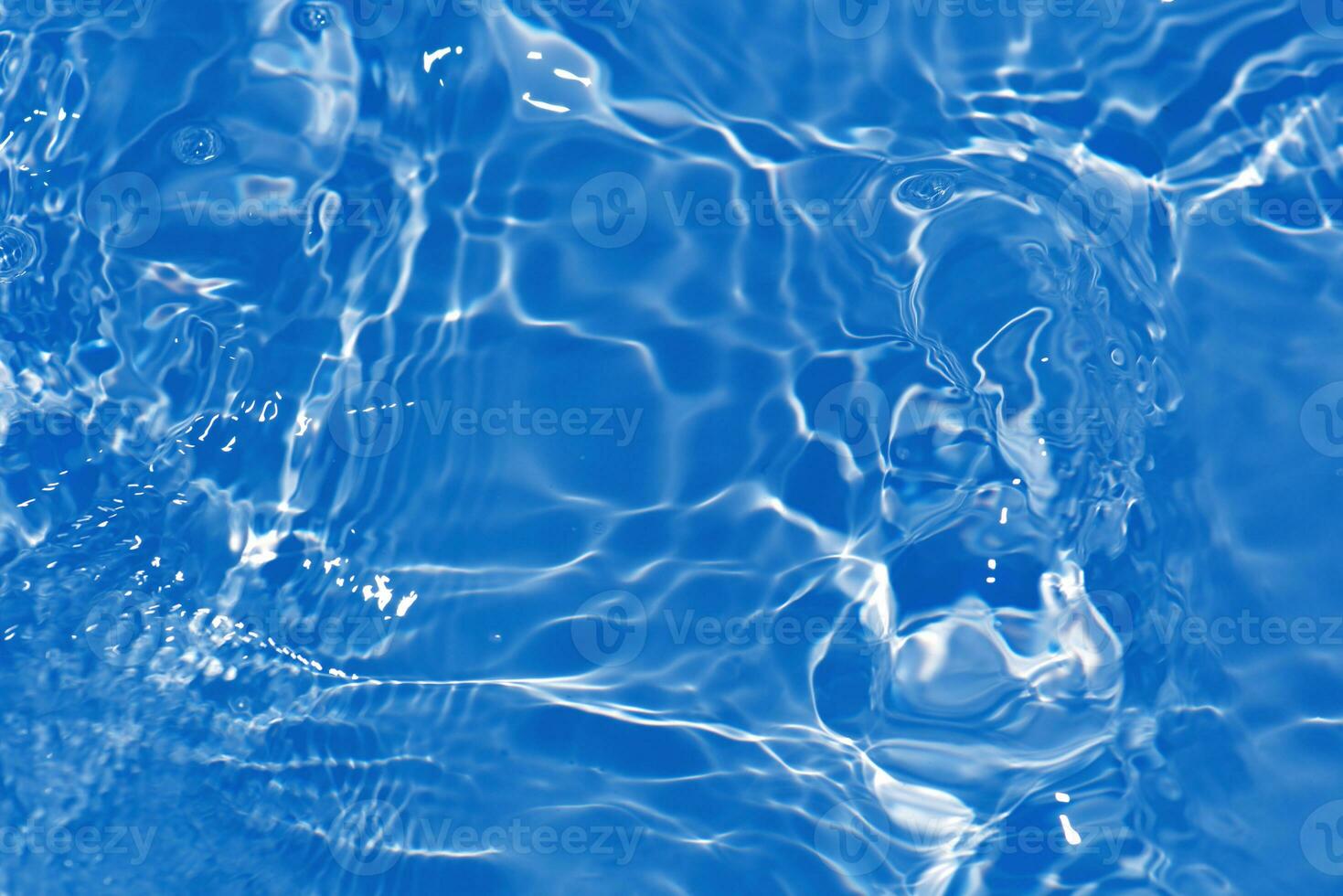 Defocus blurred transparent blue colored clear calm water surface texture with splashes reflection. Trendy abstract nature background. Water waves in sunlight with copy space. Blue watercolor shine. photo