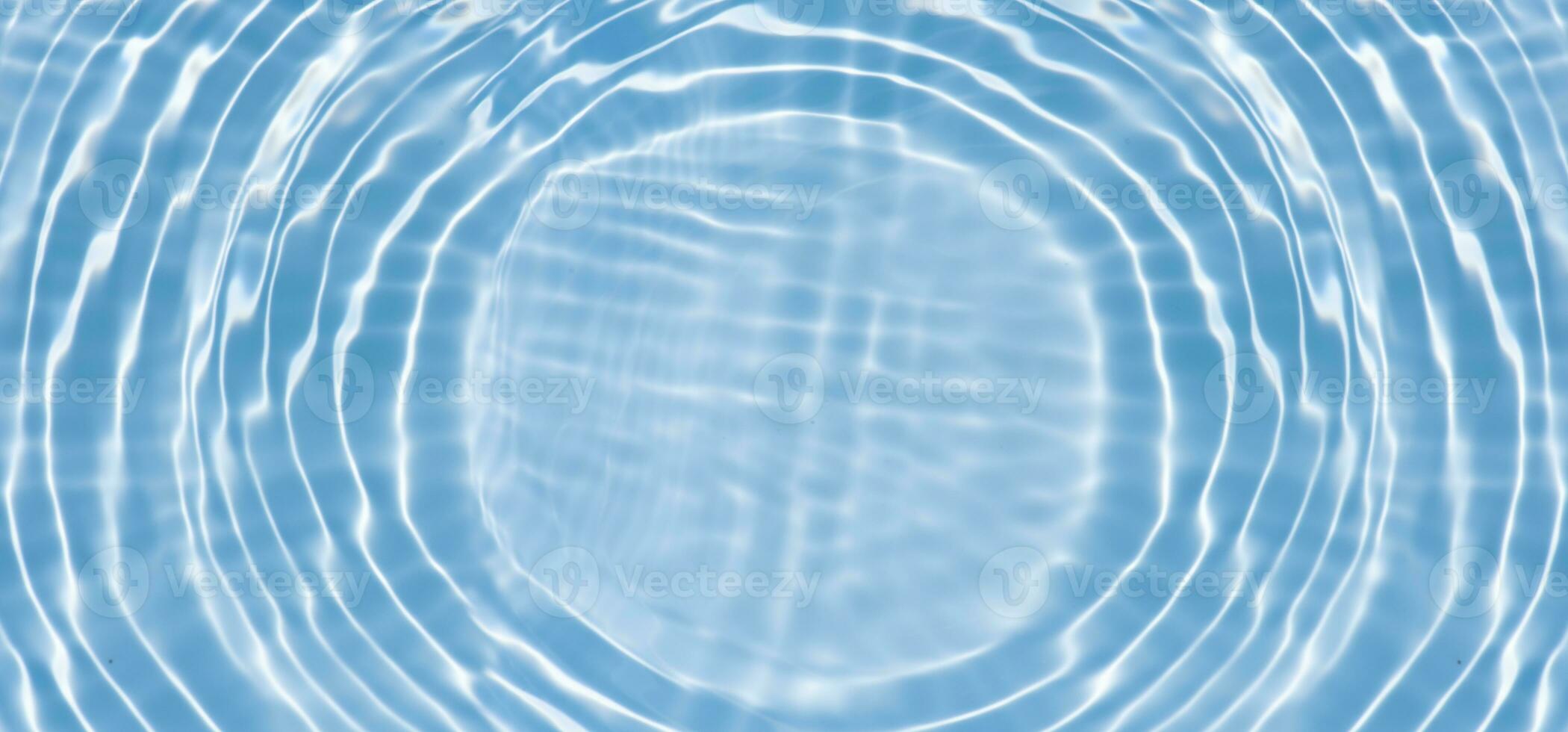 Defocus blurred transparent blue colored clear calm water surface texture with splashes reflection. Trendy abstract nature background. Water waves in sunlight with copy space. Blue watercolor shine. photo