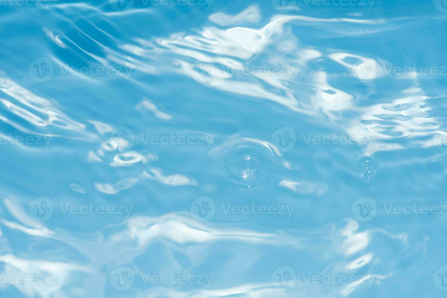 Defocus blurred transparent blue colored clear calm water surface texture with splashes reflection. Trendy abstract nature background. Water waves in sunlight with copy space. Blue watercolor shine. photo