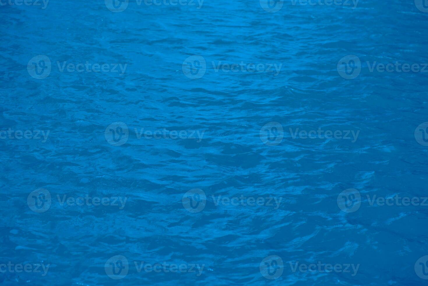 Defocus blurred transparent blue colored clear calm water surface texture with splashes reflection. Trendy abstract nature background. Water waves in sunlight with copy space. Blue watercolor shine. photo