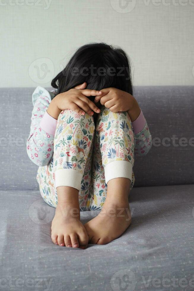 a upset child girl cover her face with hand photo