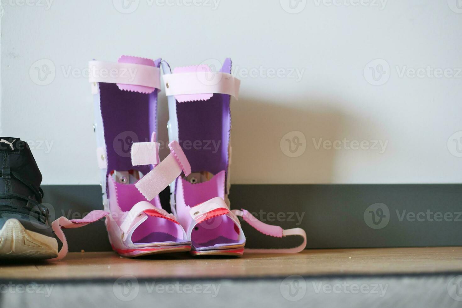 Child cerebral palsy disability, legs orthosis shoes on floor photo