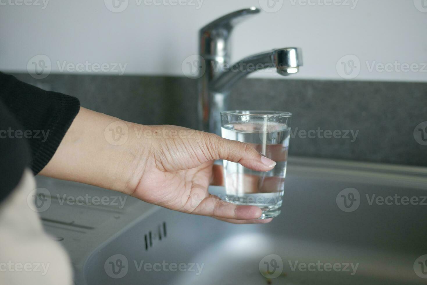 water pouring from a faucet tap in a glass, drinking pure water concept photo