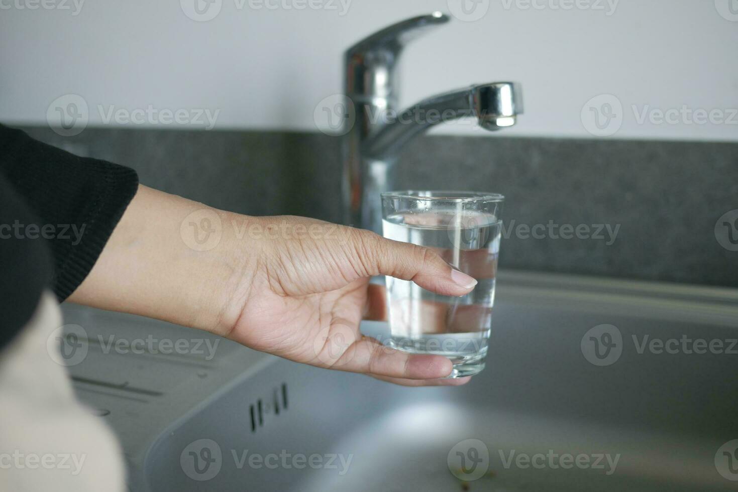 agua torrencial desde un grifo grifo en un vaso, Bebiendo puro agua concepto foto