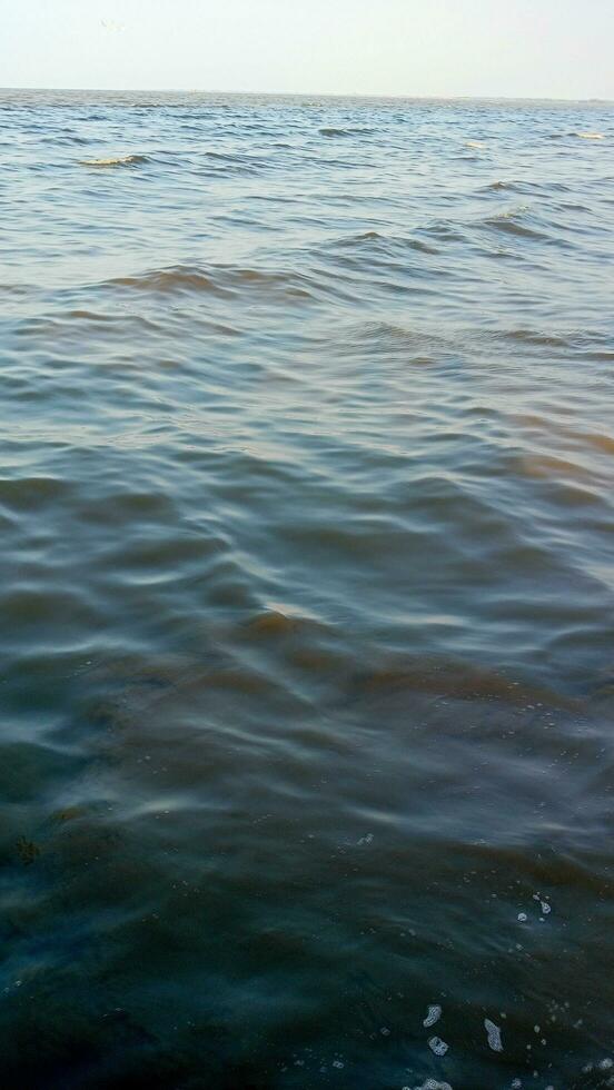 a brown river with rocks and water photo