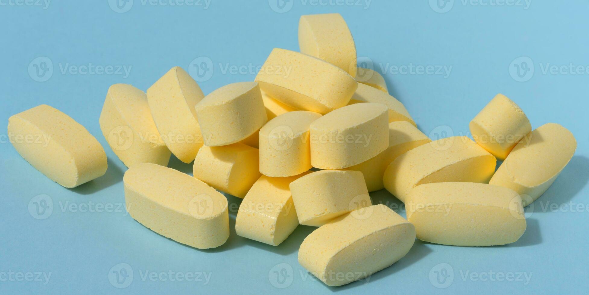 Yellow oval tablets on a blue background photo