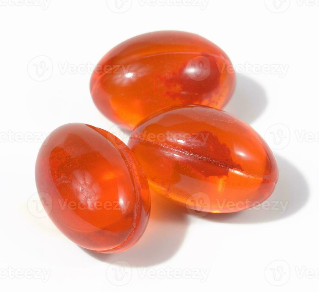 Orange capsules with fish oil on a white background, top view photo