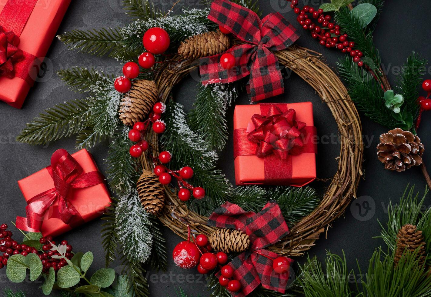 Christmas wreaths, fir branches and gifts on a black background. View from above photo