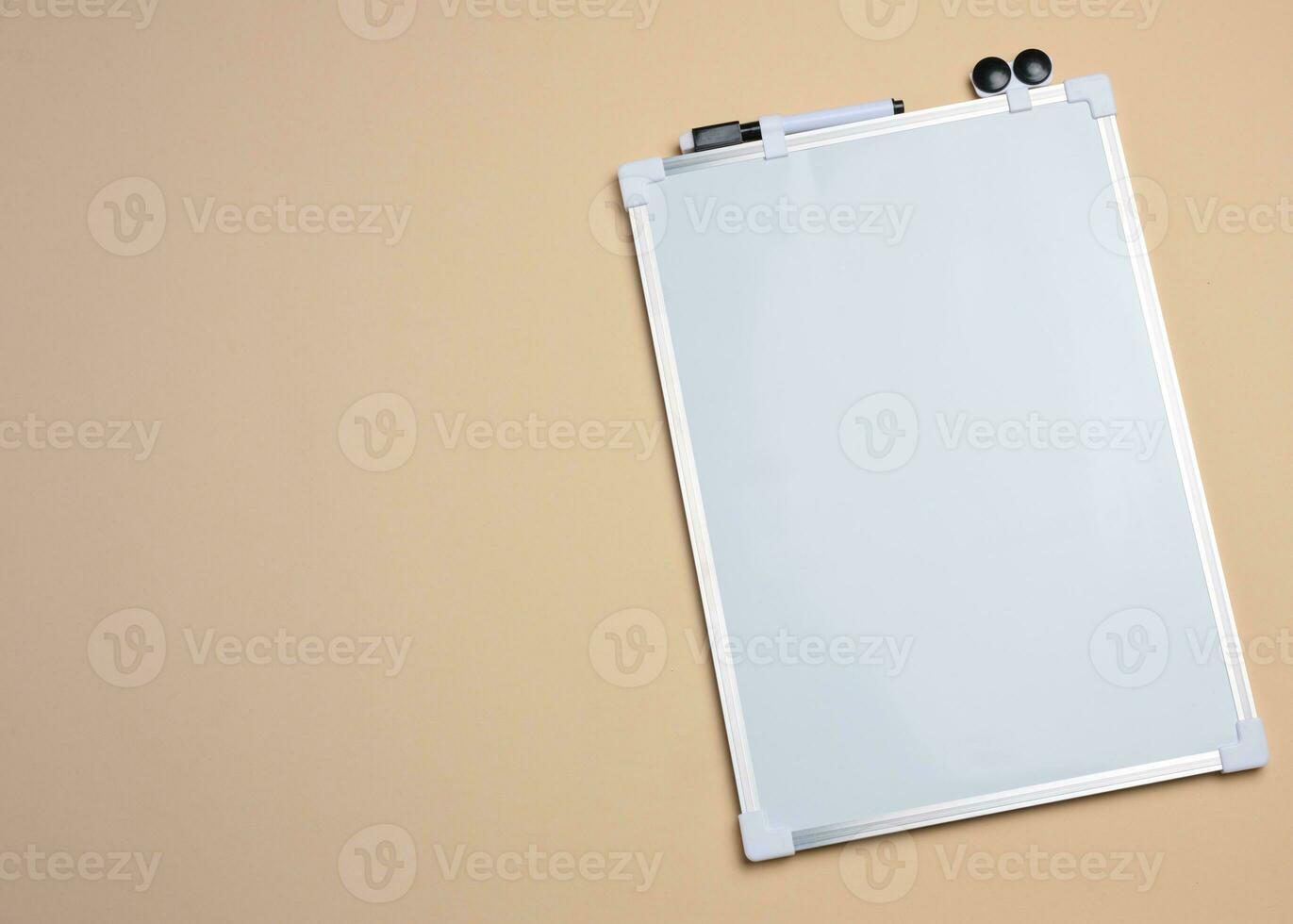 Empty white board for markers on beige background photo