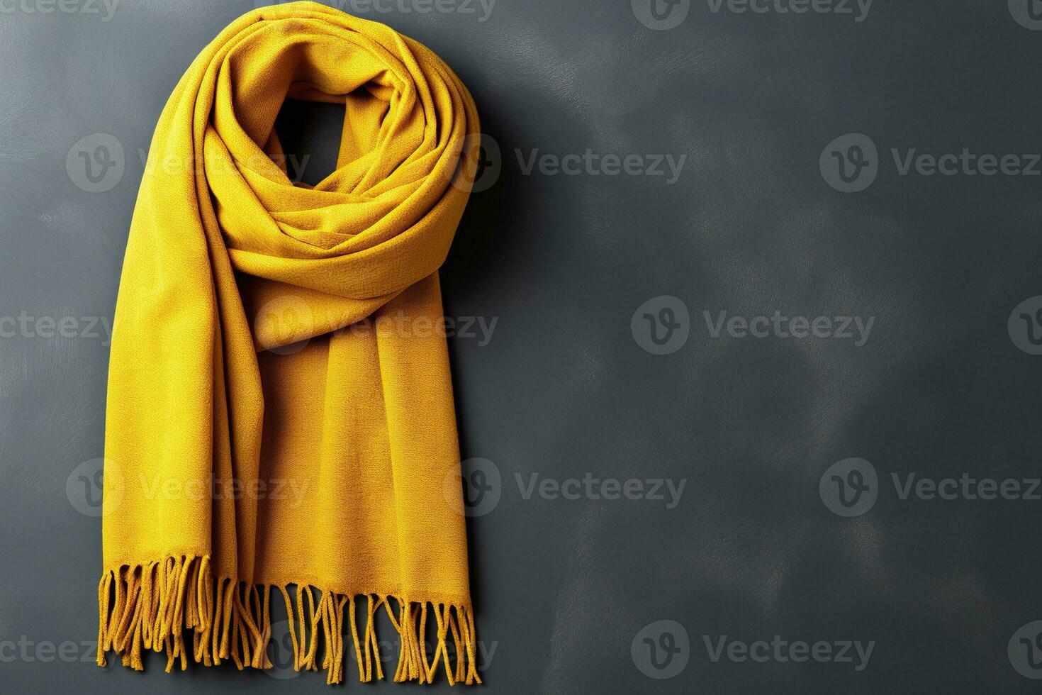 Yellow warm scarf on a background of a gray concrete wall. Generated by artificial intelligence photo