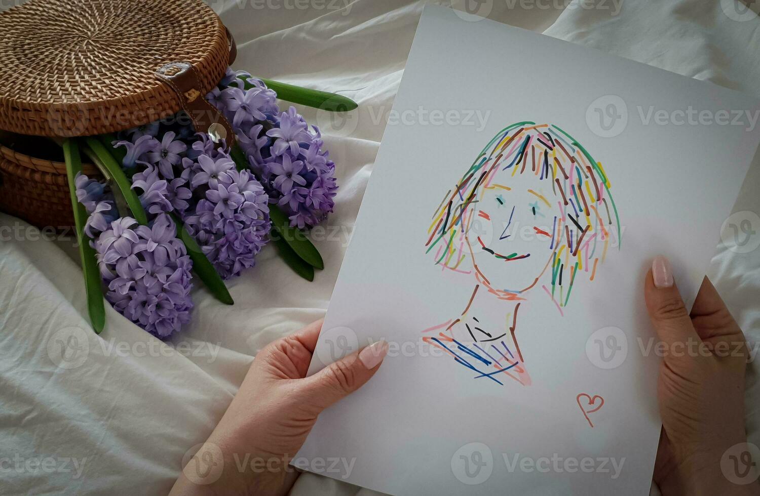 Mom holds a drawing of a child in her hands photo