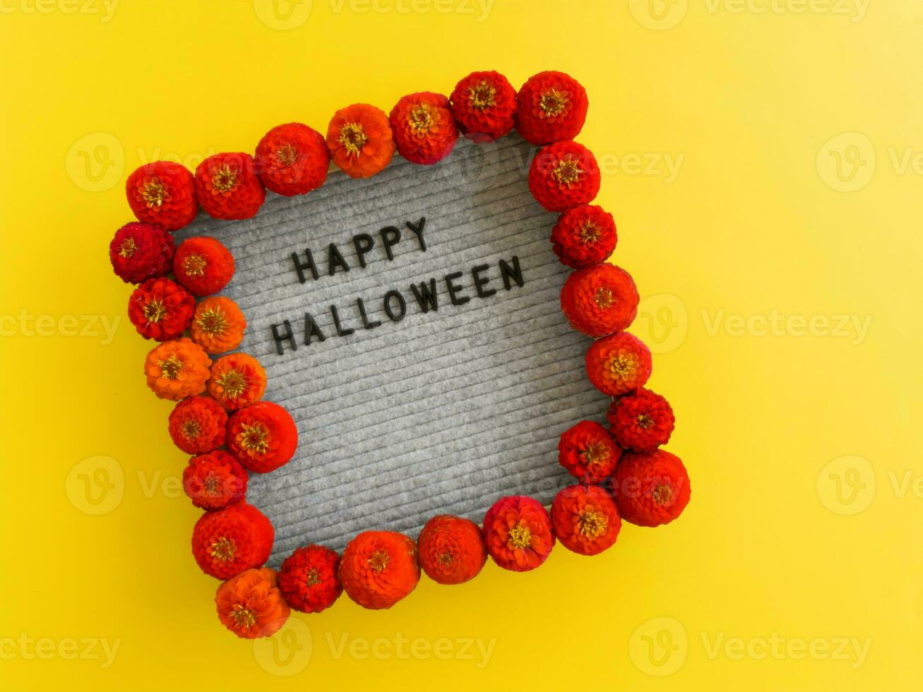 The inscription happy Halloween is laid out in a frame with red flowers of cynia. photo
