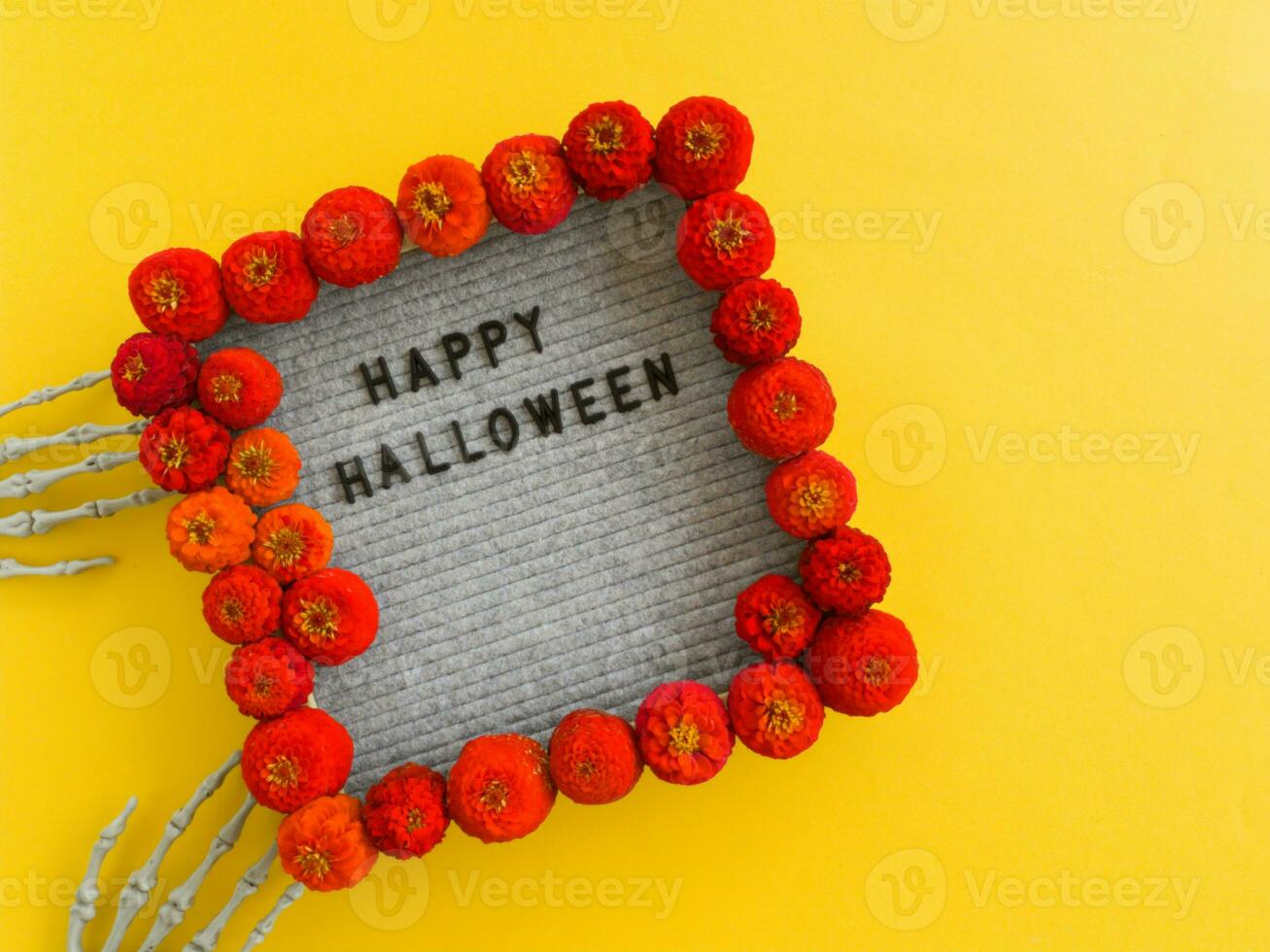 In a frame with red flowers, the inscription is laid out happy Halloween. photo