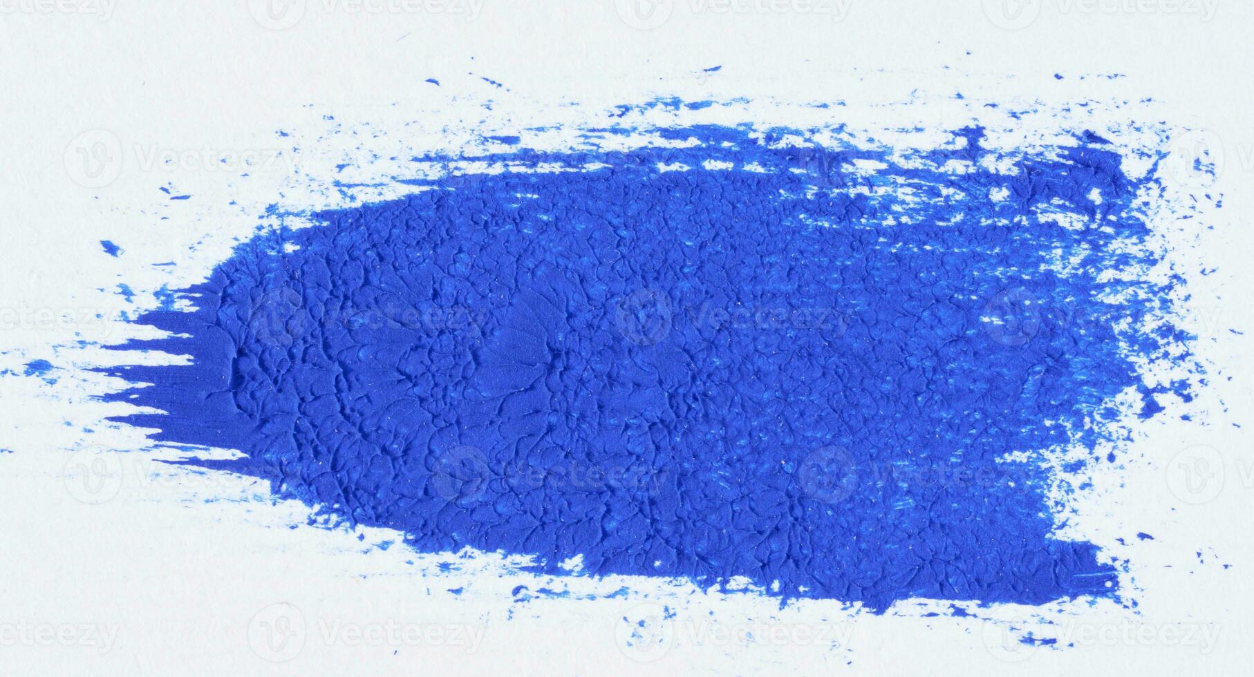 A stroke of blue acrylic paint on a white sheet of paper photo