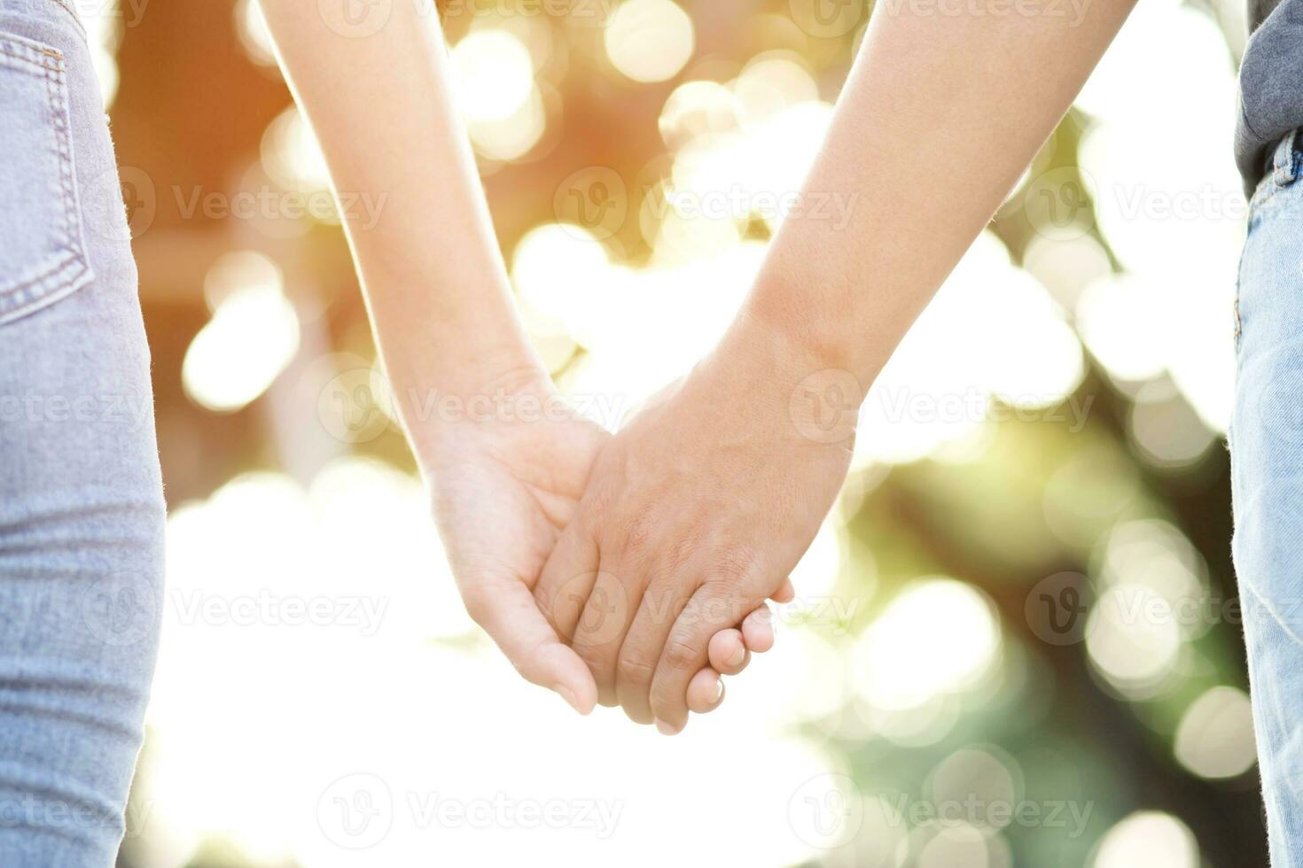 Couple lovers romantic holding hands towards with bright sun flare in public parks, or close up view in a conceptual image first love adolescent young relationship. lover photo