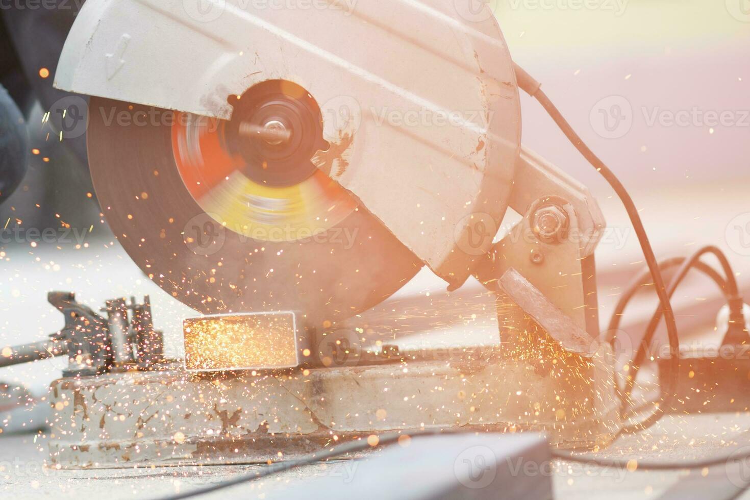 A worker cutting steel with a steel cutting machine sparked at a construction site. photo