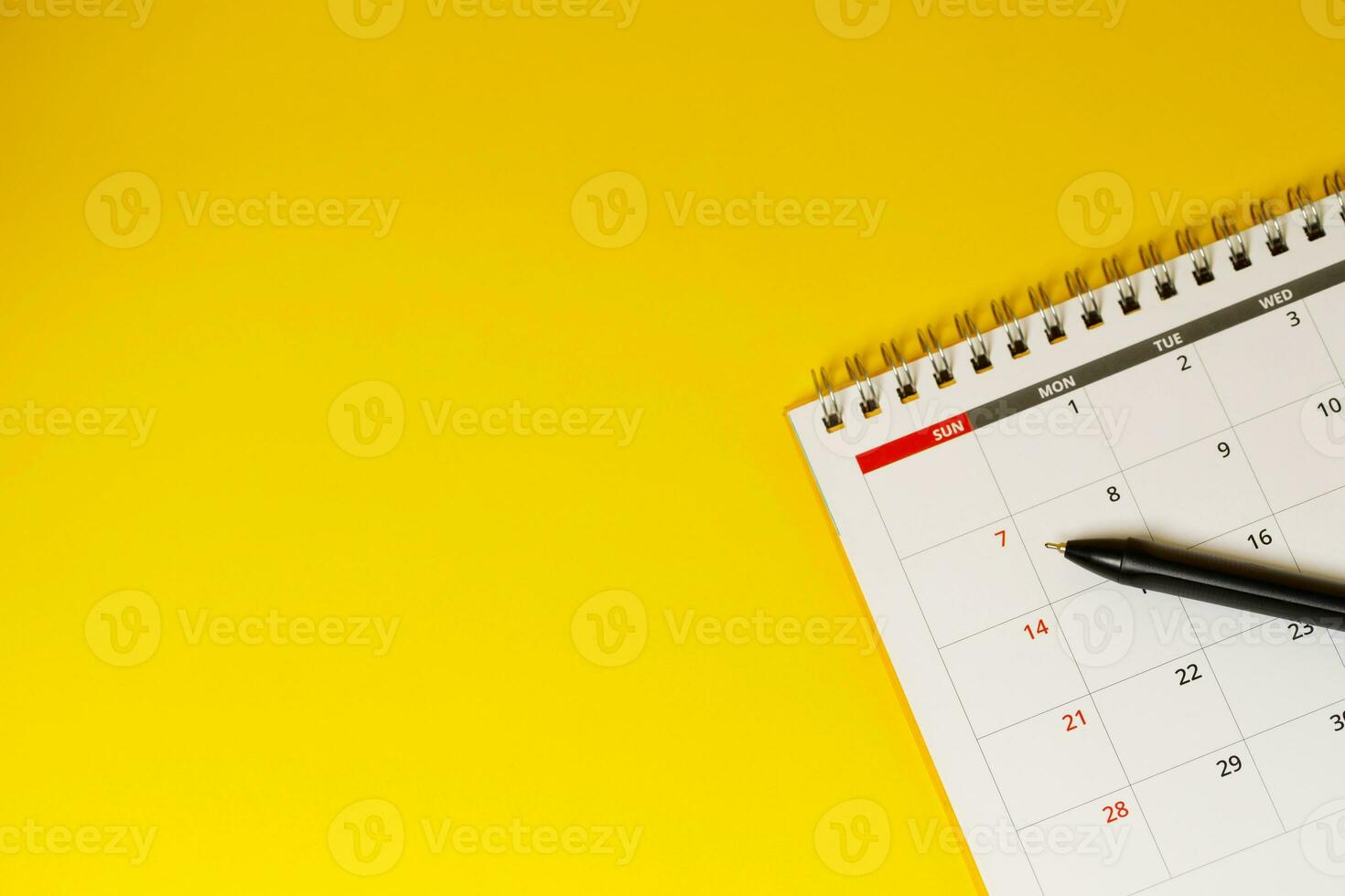 calendar month schedule to make appointment meeting or manage timetable each day lay and pen on yellow background for planning work and travel concept. photo