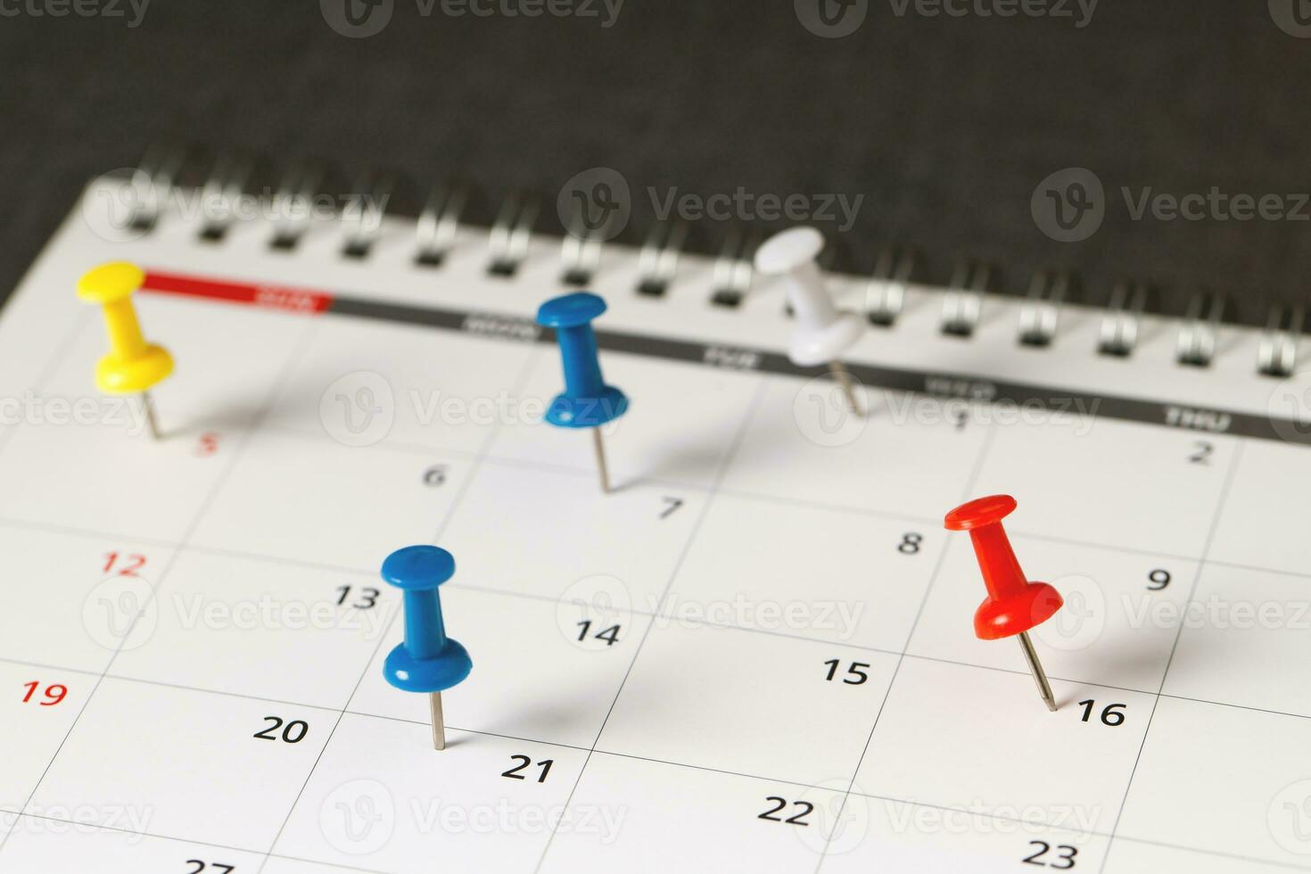 mark the event day with a pin. Thumbtack in calendar concept for busy timeline organize schedule,appointment meeting reminder. planning business meeting or travel holiday planning concept. soft focus photo