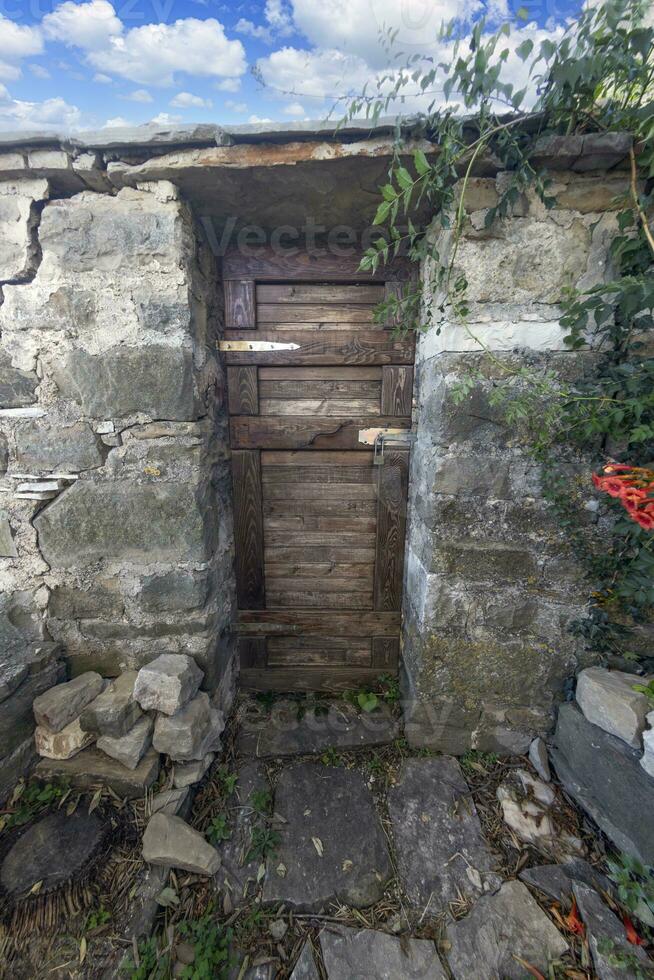 Image of a wooden entrance door to a building with an antique facade photo