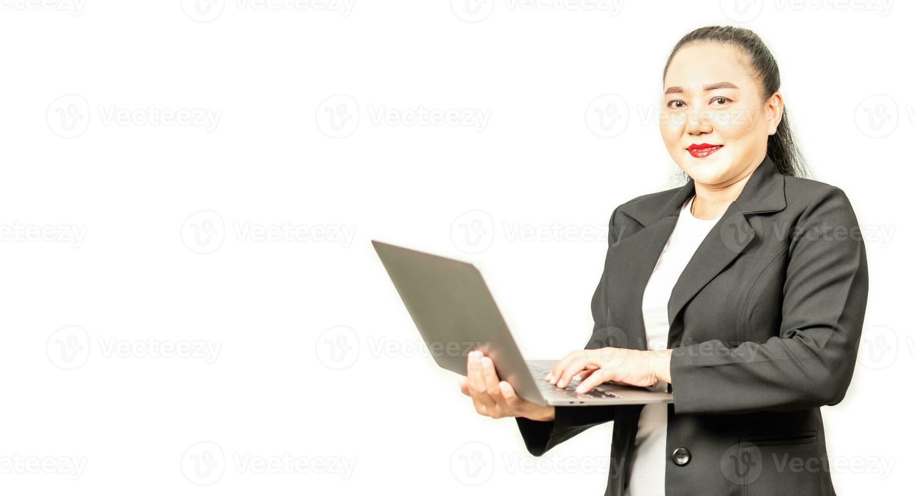 Portrait of a happy Asian businesswoman smiling and looking at the camera, working on a laptop computer and typing on a keyboard, isolated over white background, Closeup, copy space on left for design photo