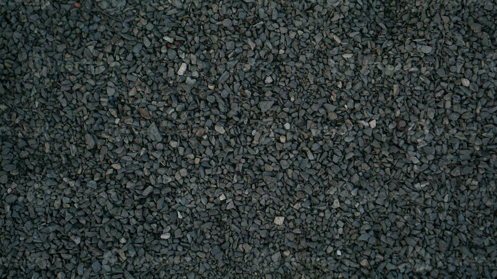 rough pebble stone texture abstract background. Grainy grey and black rock abstract background photo