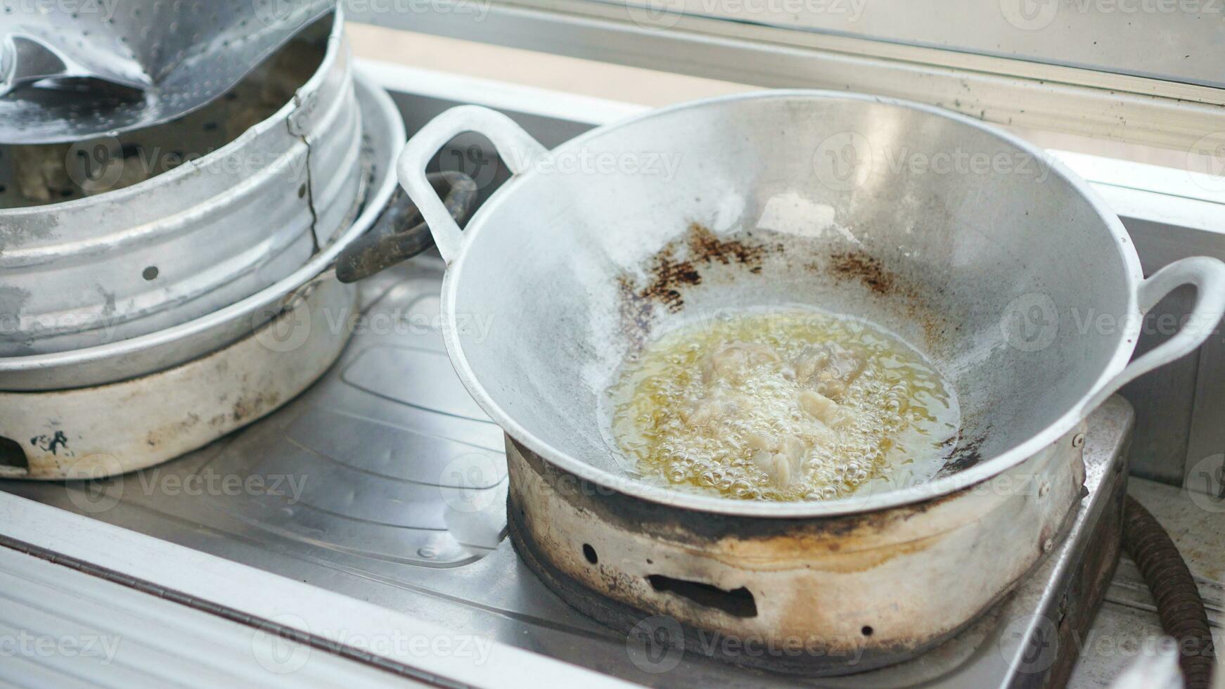 Batagor or somay is fried in hot or boiling oil on a griddle by street vendors. Batagor is Indonesian street food made of made of flour and filled with chicken or beef or vegetable photo