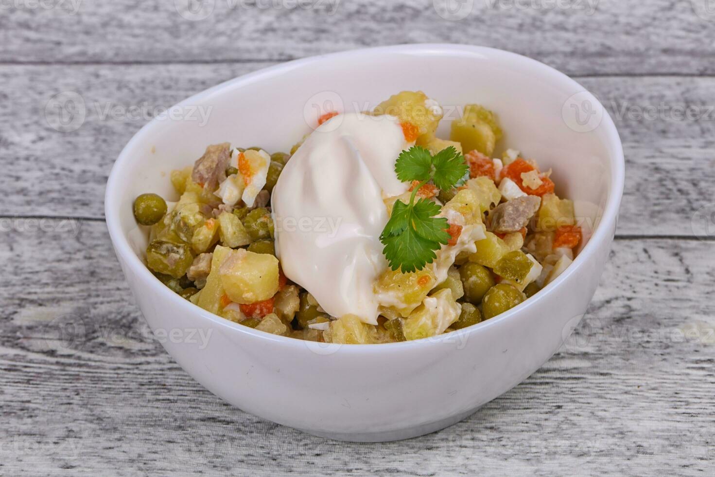 ensalada rusa tradicional con pollo en el tazón blanco foto