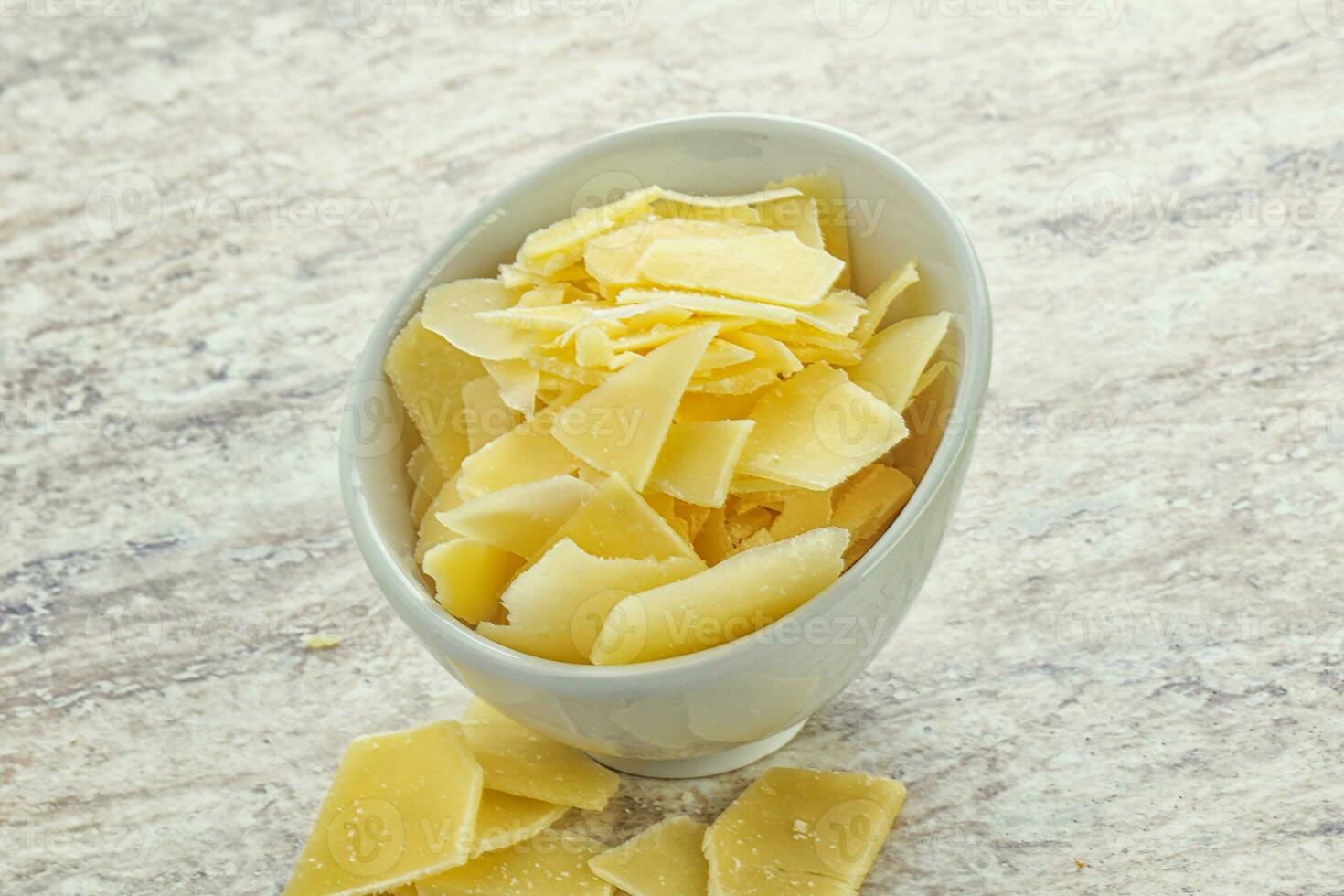 Sliced parmesan cheese heap in the bowl photo