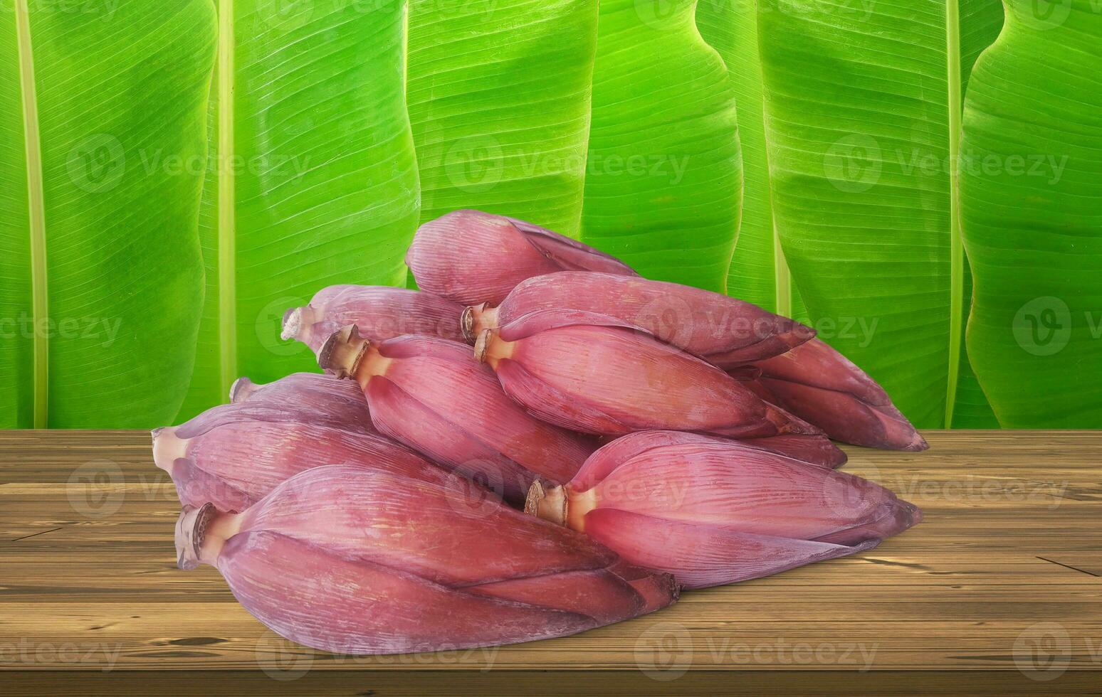 Banana flowers on a wooden table banana leaf background photo