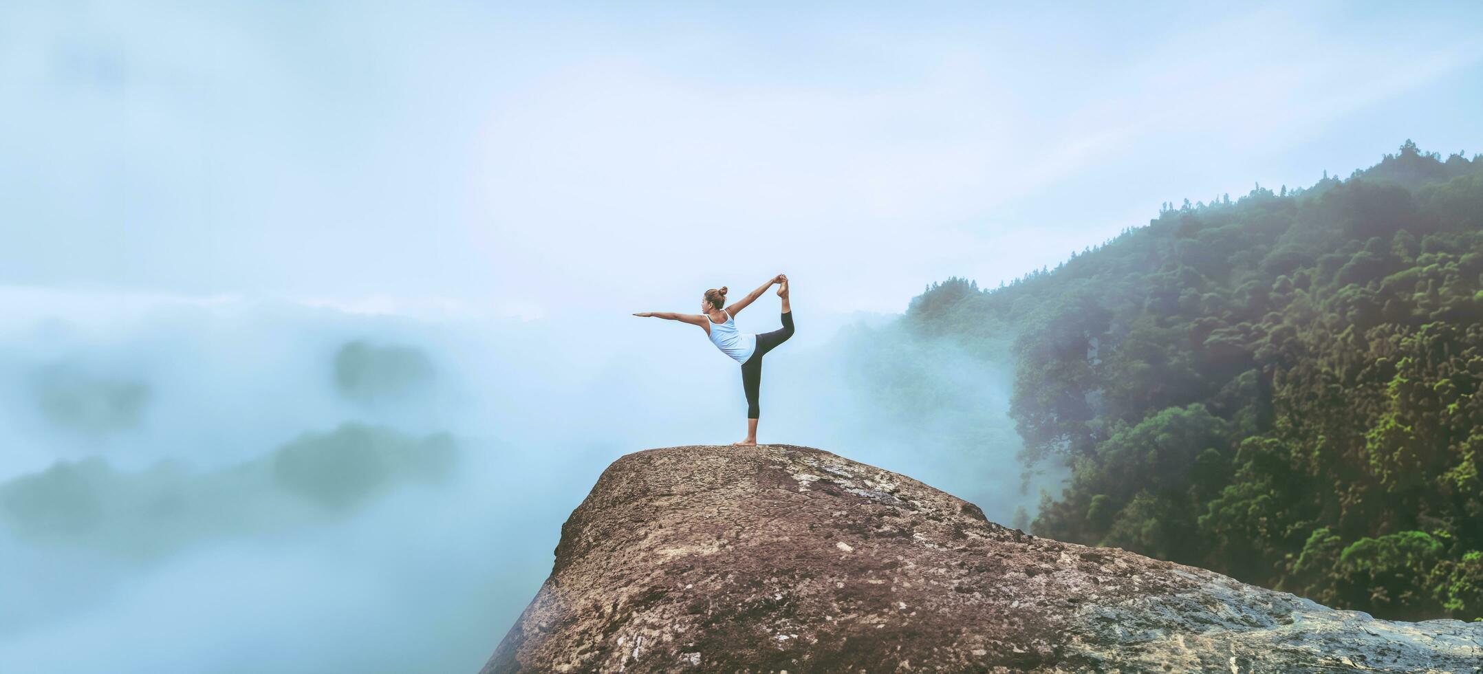 Asian women relax in the holiday. Travel relax.  Play if yoga. On the Moutain rock cliff. Nature of mountain forests in Thailand photo