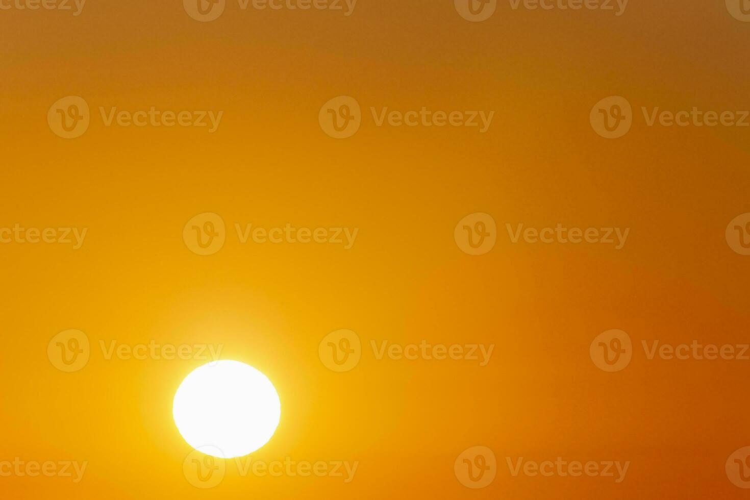 rising sun against clear orange sky photo