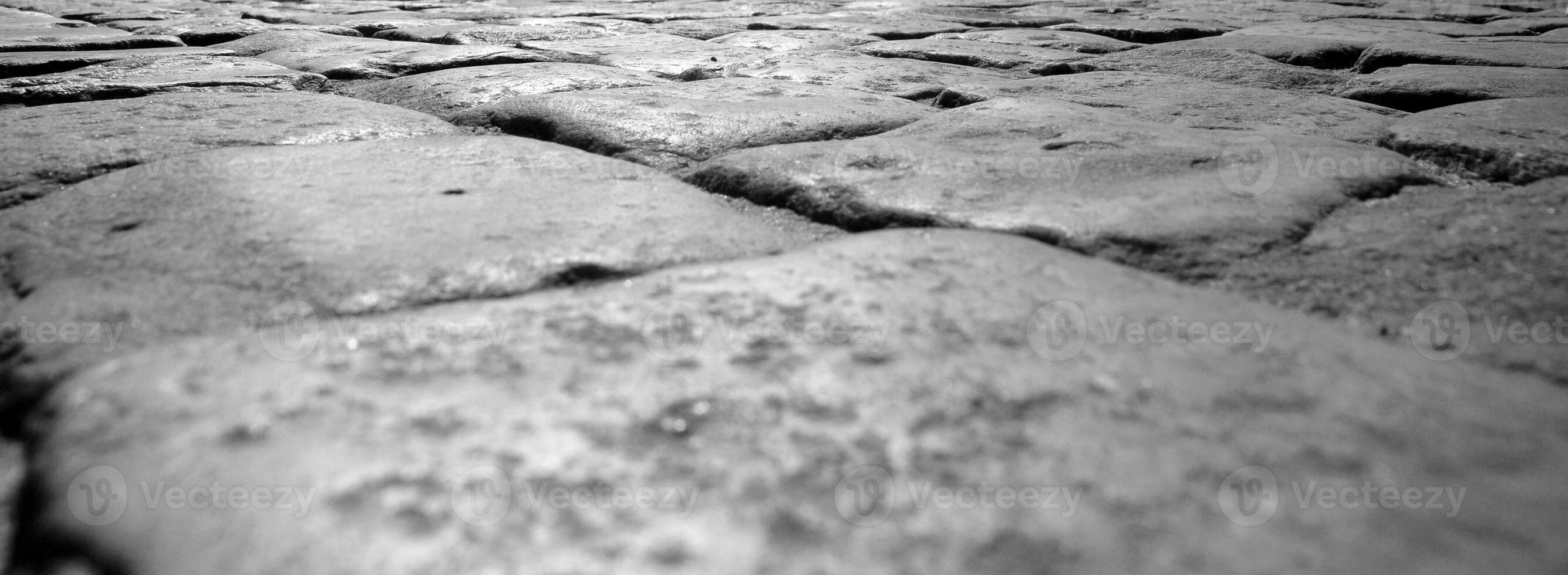 Stone pavement of the road, close view black and white background photo