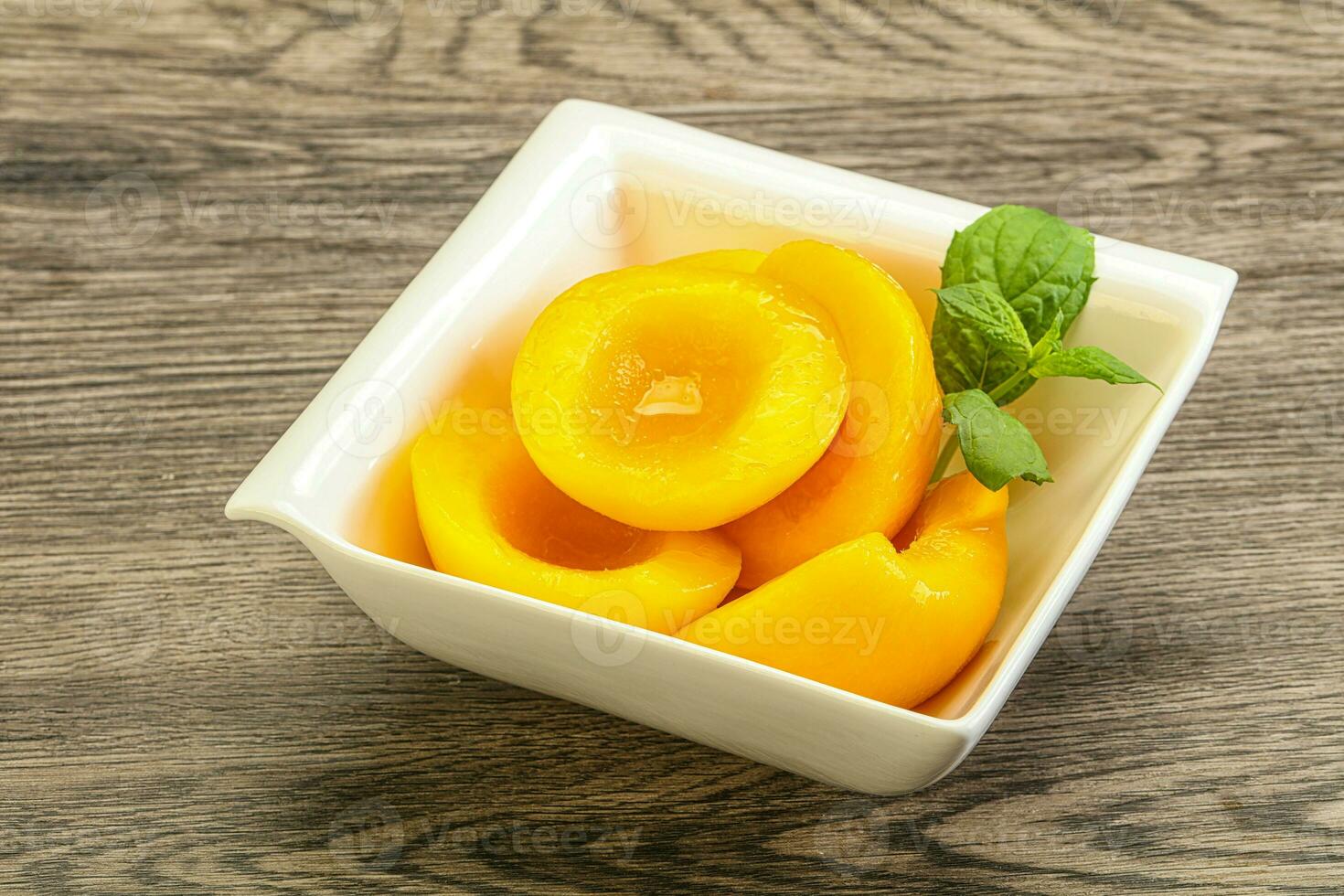 Sweet ripe canned peaches with mint photo