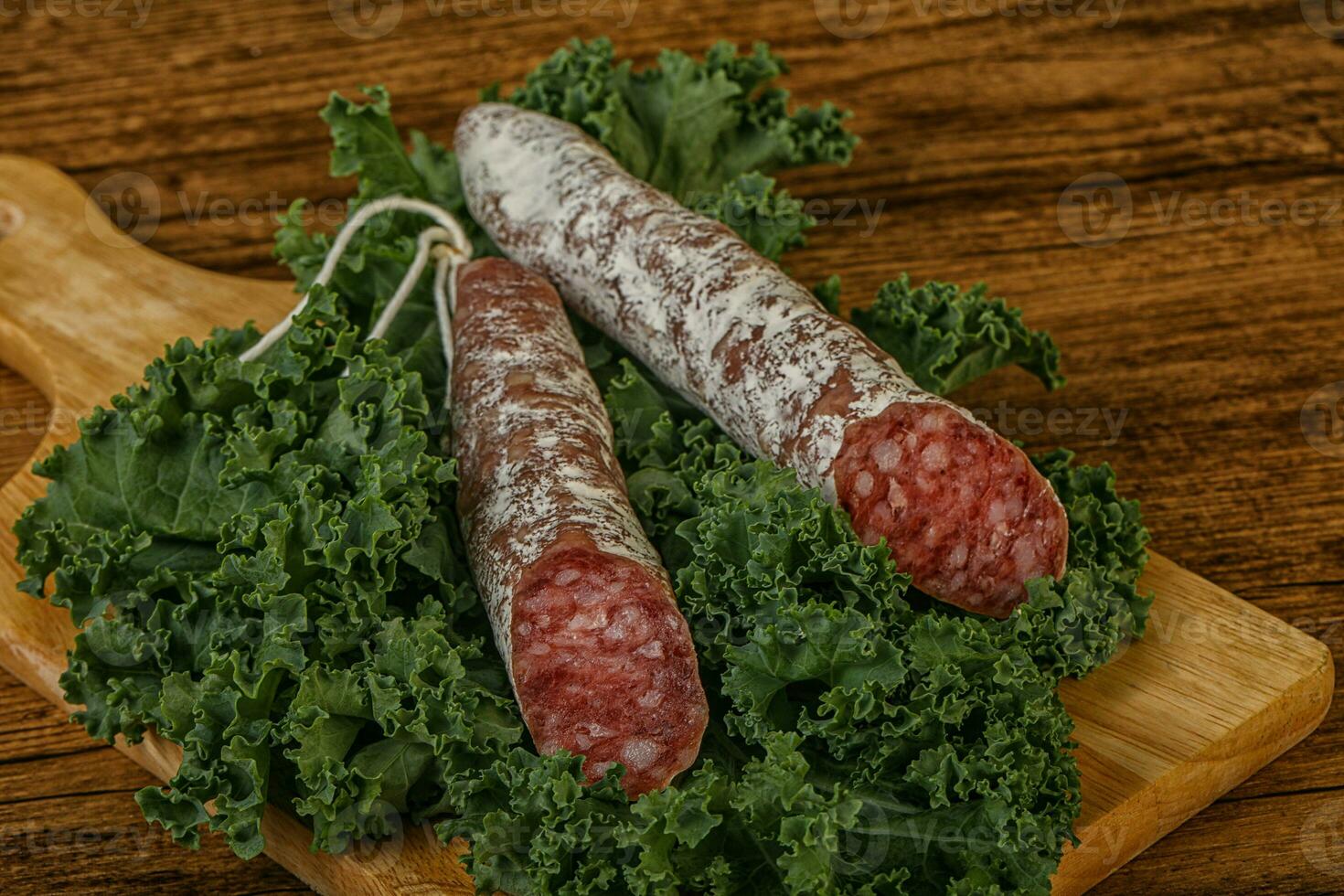 Salchichón de fuet español con hojas de ensalada foto