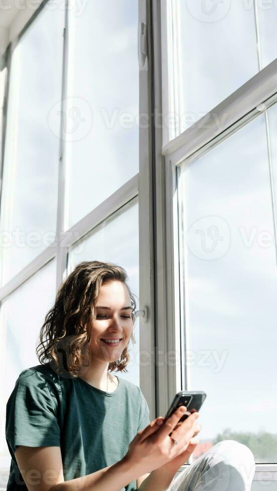 Connected in Solitude. A Young Woman Embraces Technology for Communication and Connection While Practicing Social Distancing at Home photo