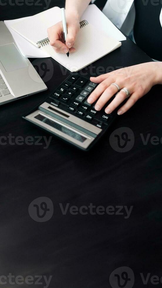 Diligent Businesswoman in Finance. Analyzing Budget, Calculating Finance Report with Calculator, Close-Up of Document. Calculating Finance Report. Woman Working in Finance and Budget photo