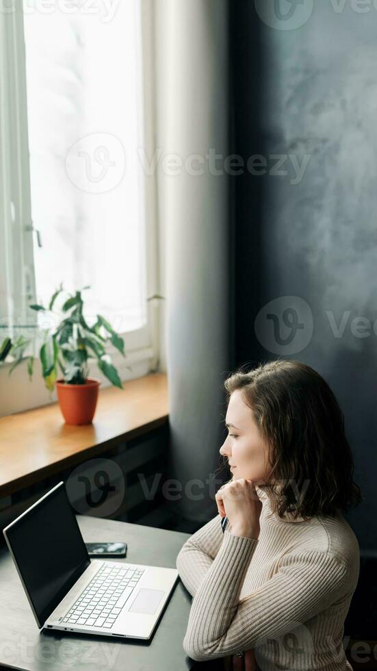 Effortless Online Shopping. Young Woman with Credit Card and Laptop. Young woman holding credit card and using laptop computer. Online shopping concept photo