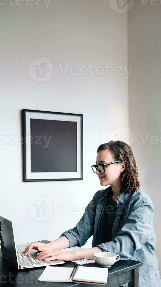 Professional young woman using laptop in office. Student girl working remotely from home. Work or study from home, freelance, business, and lifestyle concept. Technology, productivity, education photo