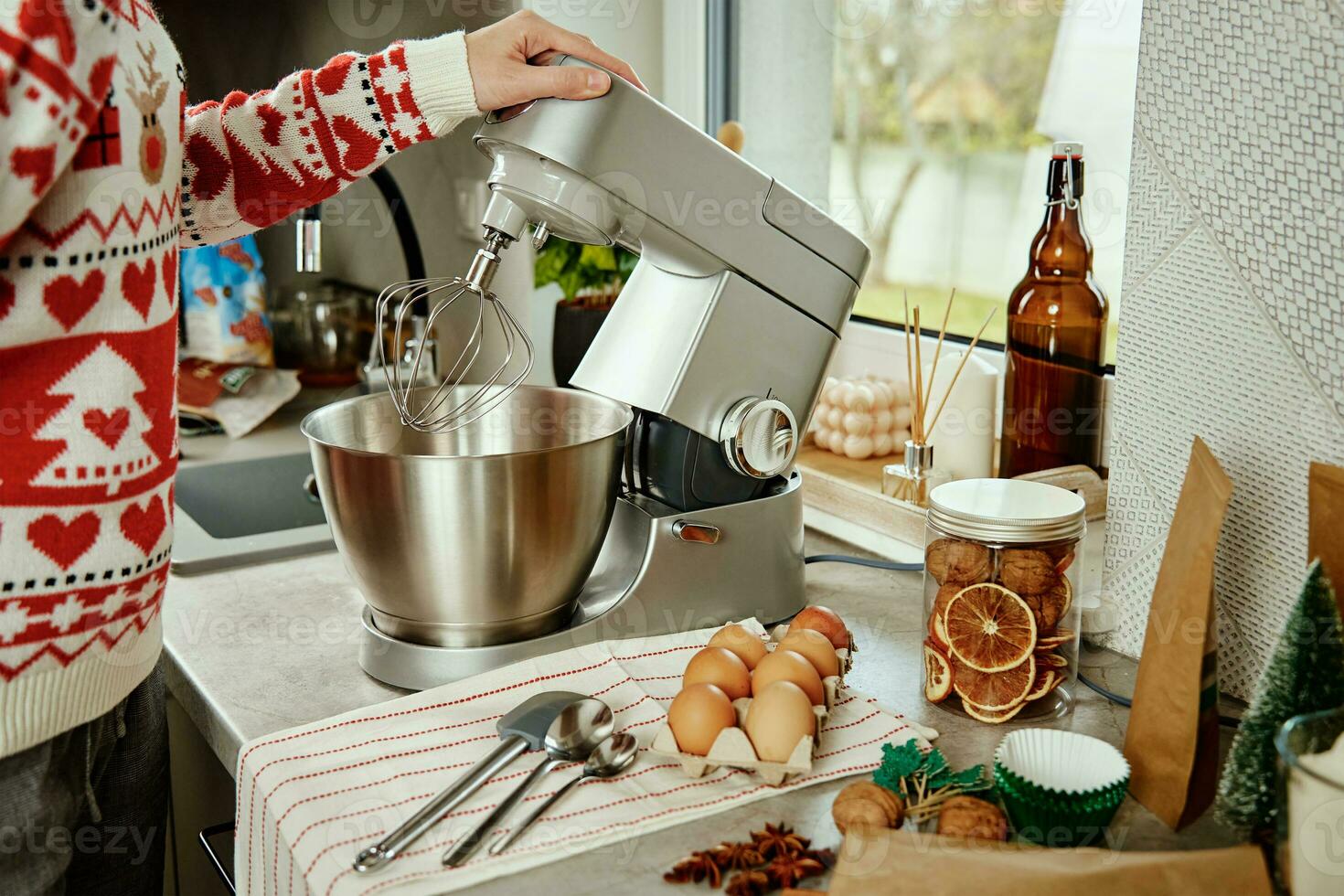 Woman cooking at home kitchen, use electric mixer to preparing dough photo