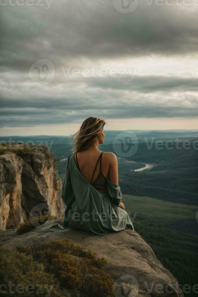 espalda ver de un mujer sentado solo a el grande montañas. ai generativo foto