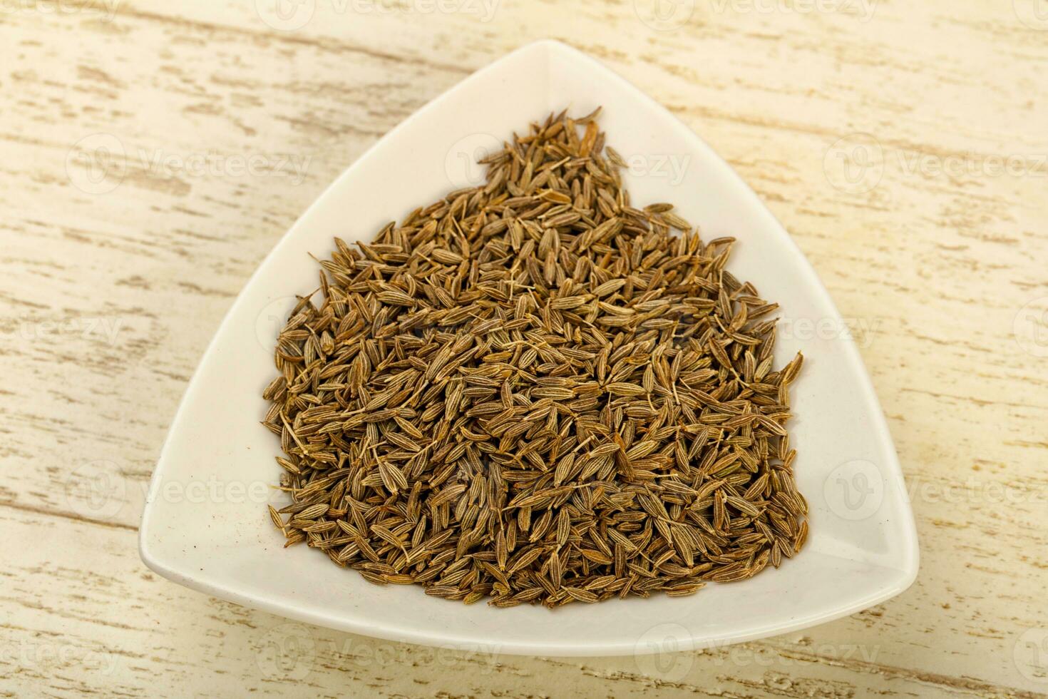 Cumin seeds over wooden background photo