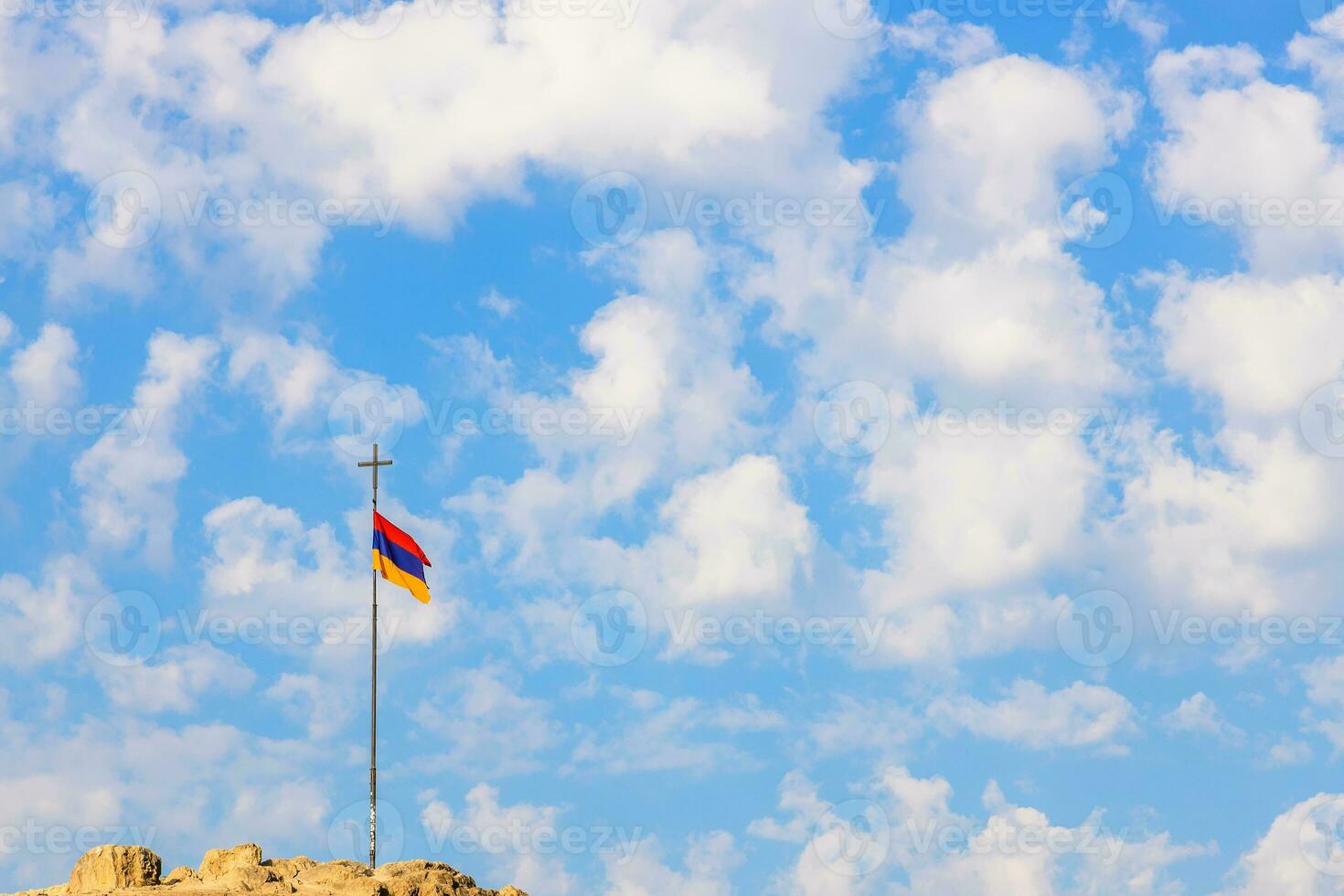 Armenian flag on pole with cross on top of hill photo