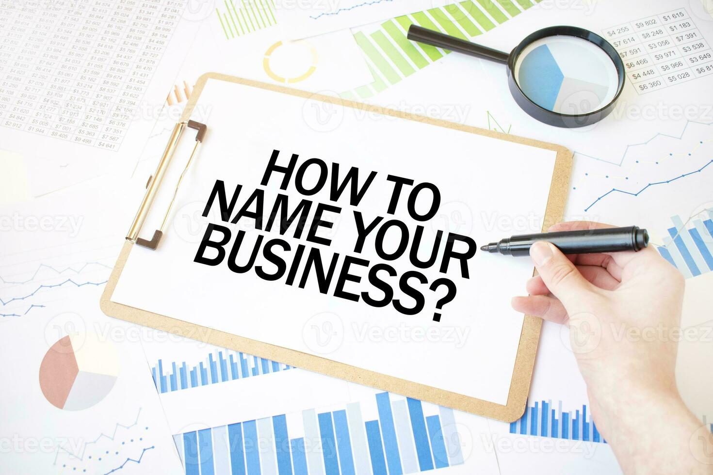 Text HOW TO NAME YOUR BUISINESS on white paper sheet and marker on businessman hand on the diagram. Business concept photo