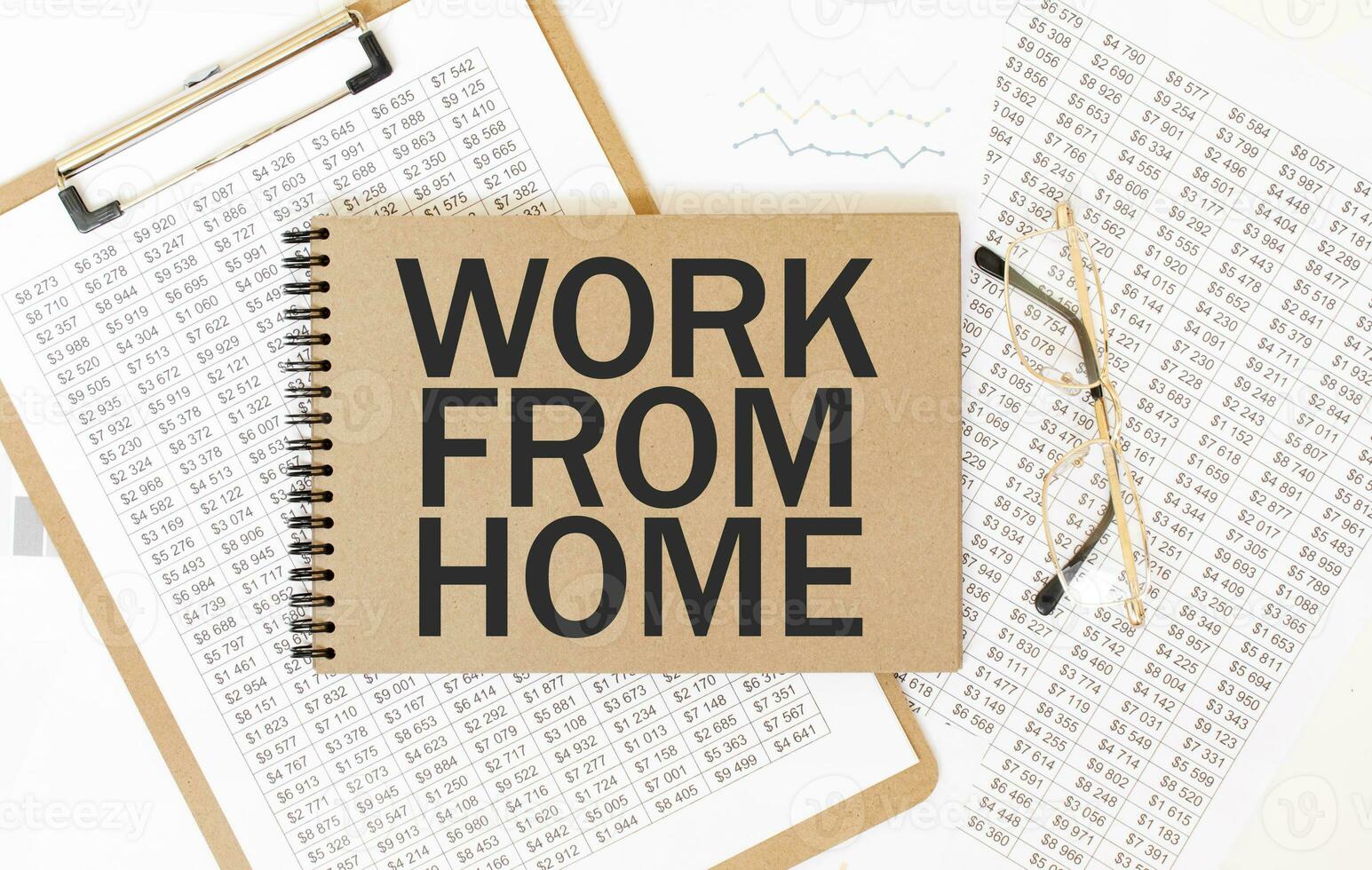 Craft colour notepad with text WORK FROM HOME. Notepad with eyeglasses and text documents. Business concept photo