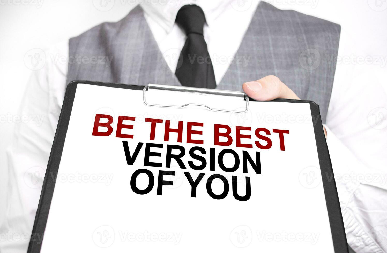 Businessman holding sheet of paper with a message BE THE BEST VERSION OF YOU photo
