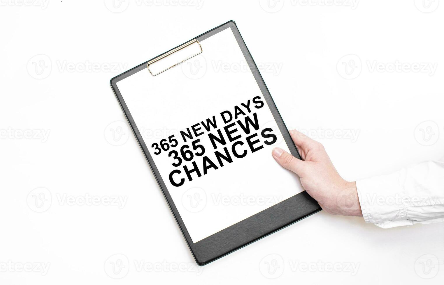 A businessman holds a folder with paper sheet with the text 365 new days 365 new chances . Business concept. photo